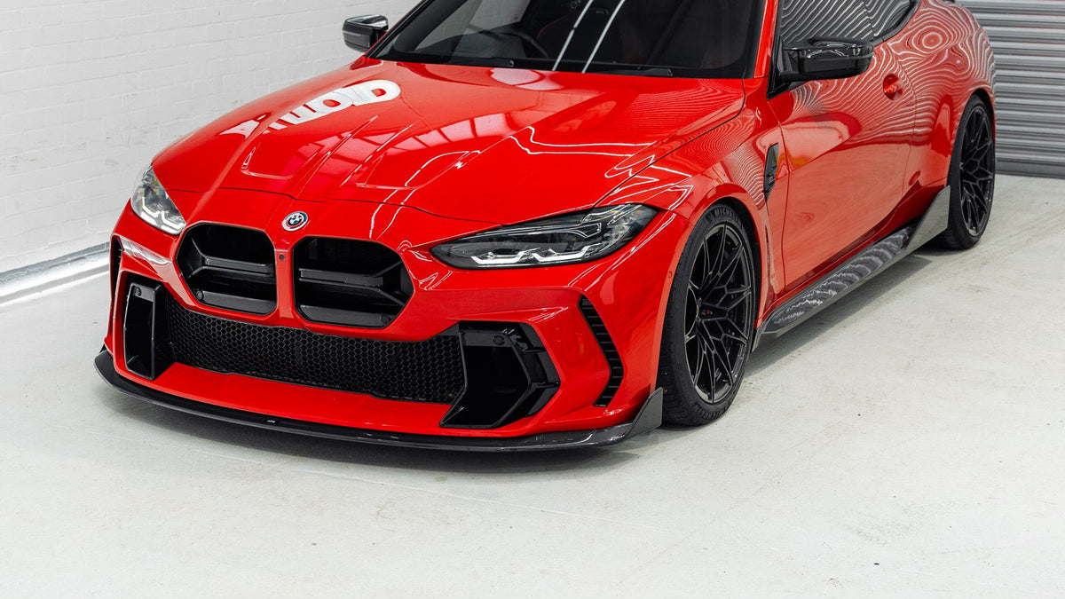 Red BMW G82 M4 with the ADRO V2 front bumper and carbon splitter, low front three-quarter view in the AUTOID studio