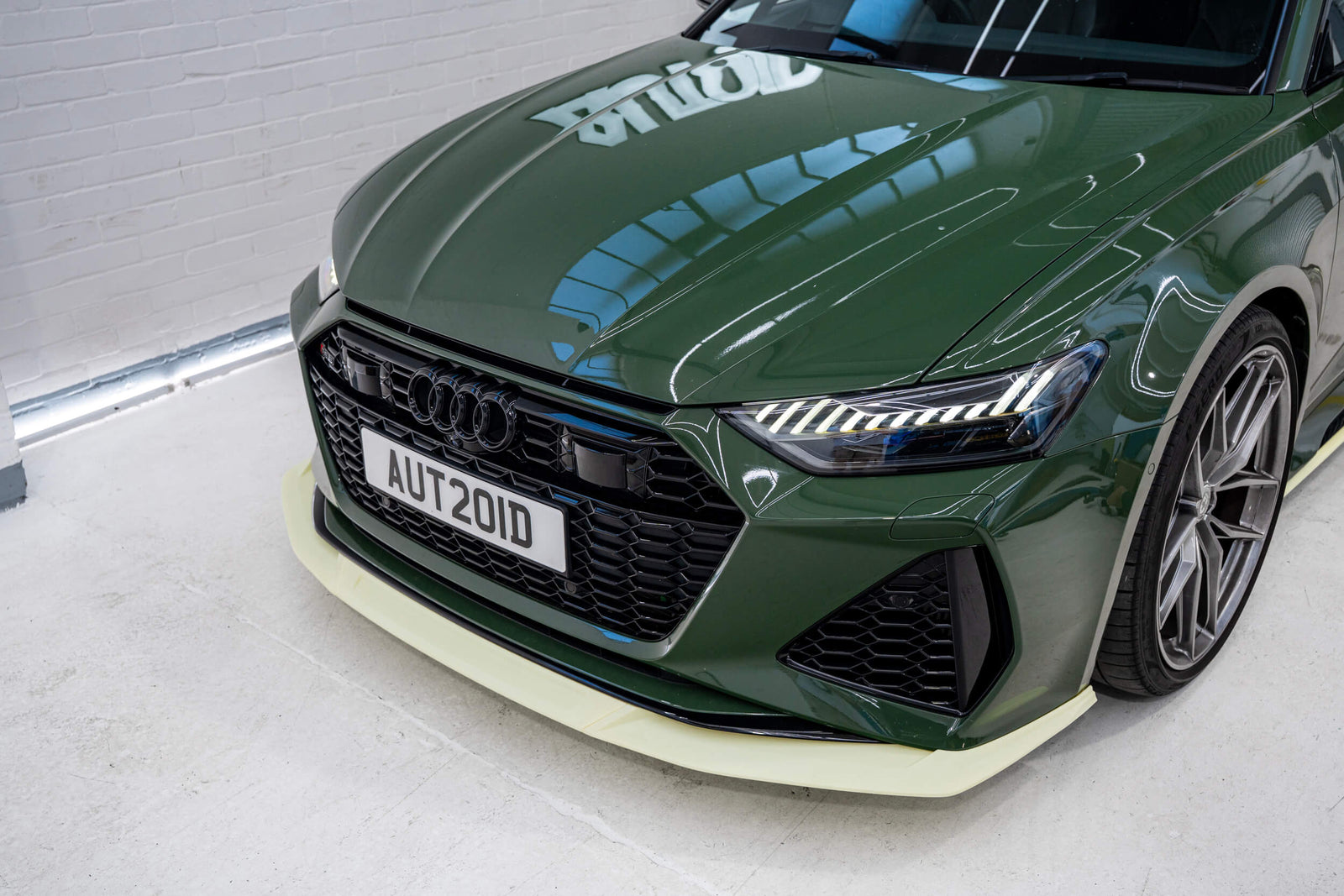 3D printed prototype front lip splitter by Trevora on modified green Audi C8 RS6 with prototype in Autoid shop.