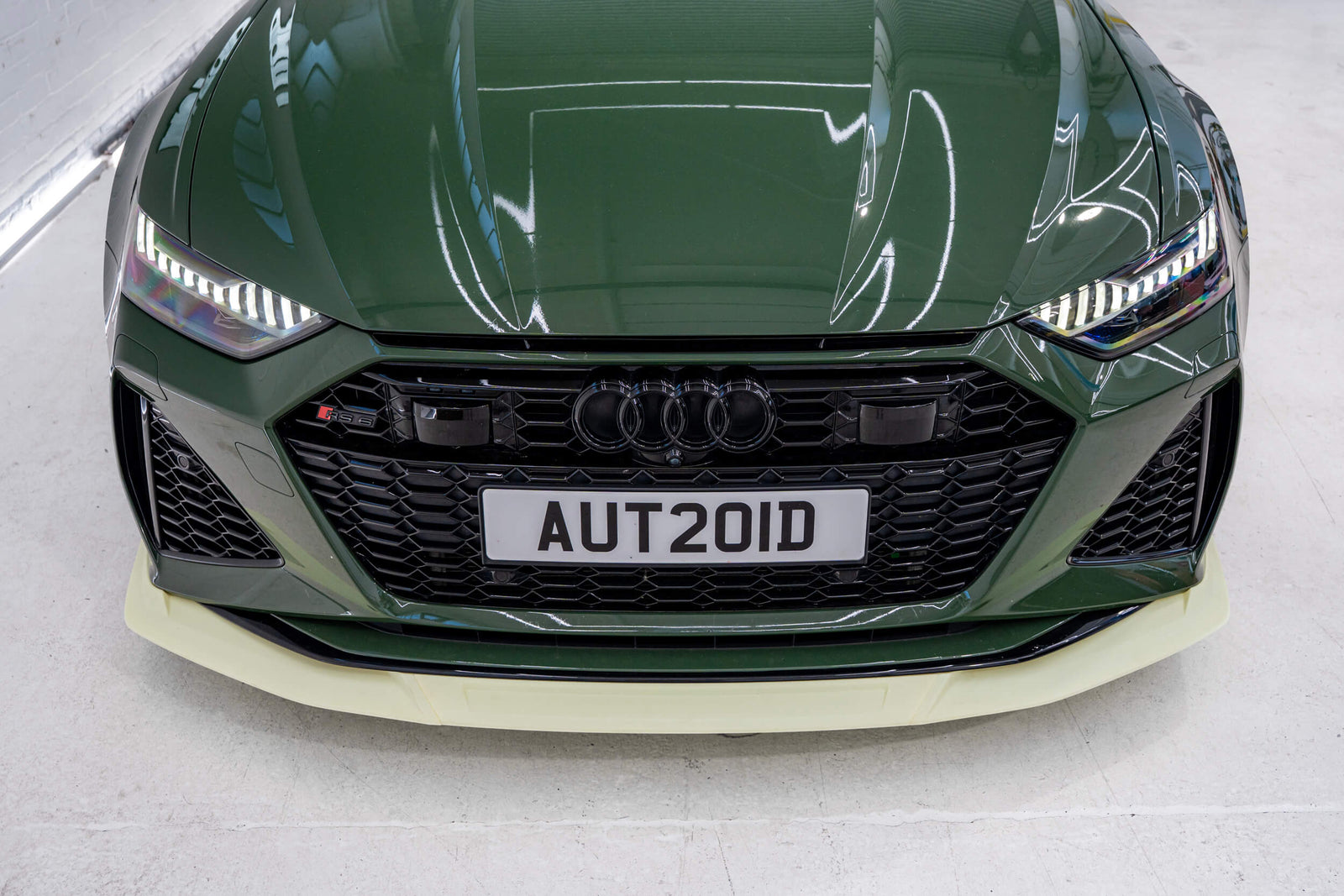 3D printed prototype front lip splitter on modified green Audi C8 RS6 with prototype in Autoid shop.