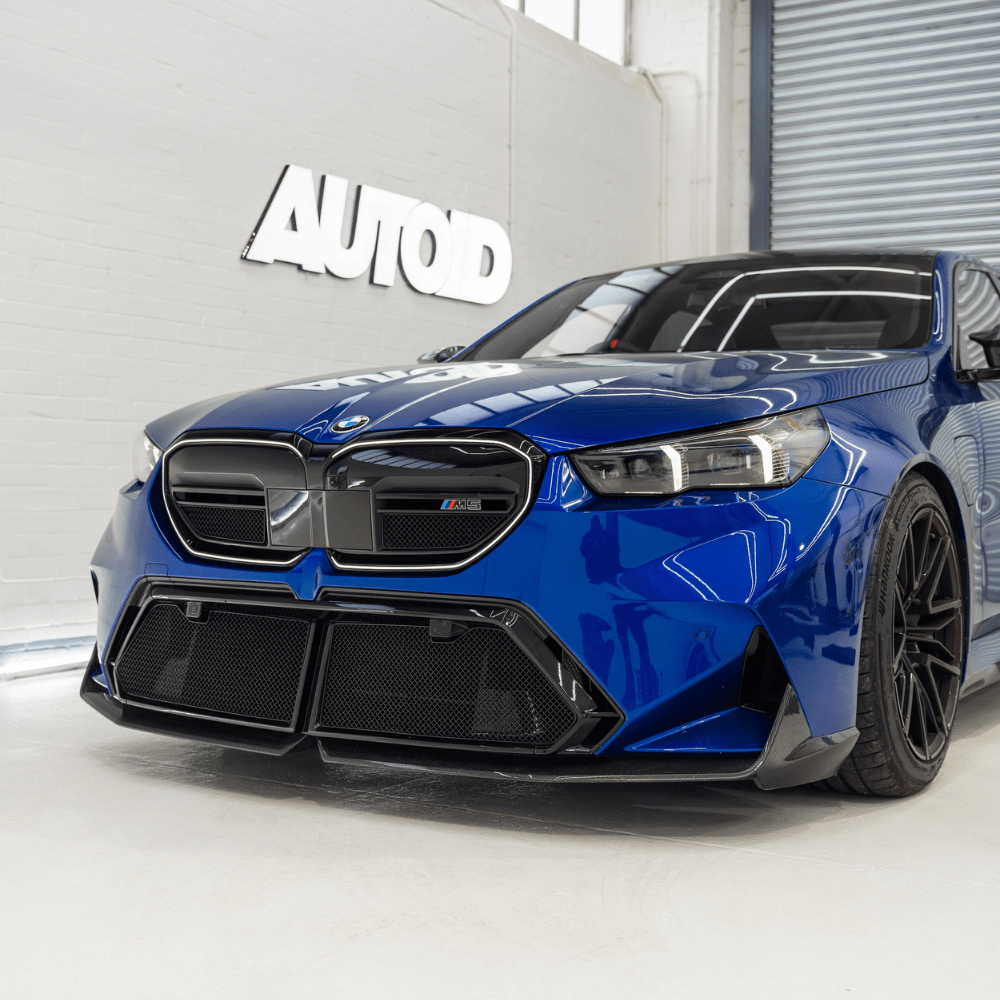 Blue BMW car in a showroom with 'AUTOD' branding on the wall.