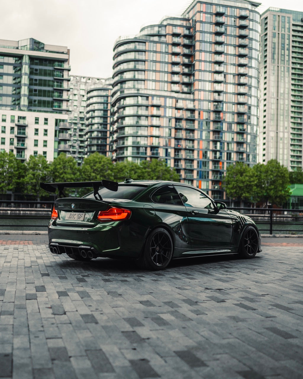 Rear of Modified BMW F87 M2 with carbon rear wing with carbon duck tail trunk, roof spoiler, carbon rear diffuser, carbon side skirts, carbon vented wings, and 2forge zf6 wheels