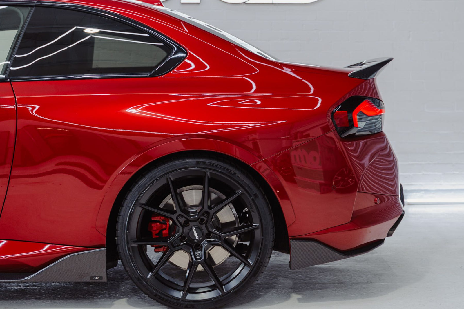 BMW G42 M240i rear quarter view showing ADRO carbon fibre side skirt end and rear spoiler