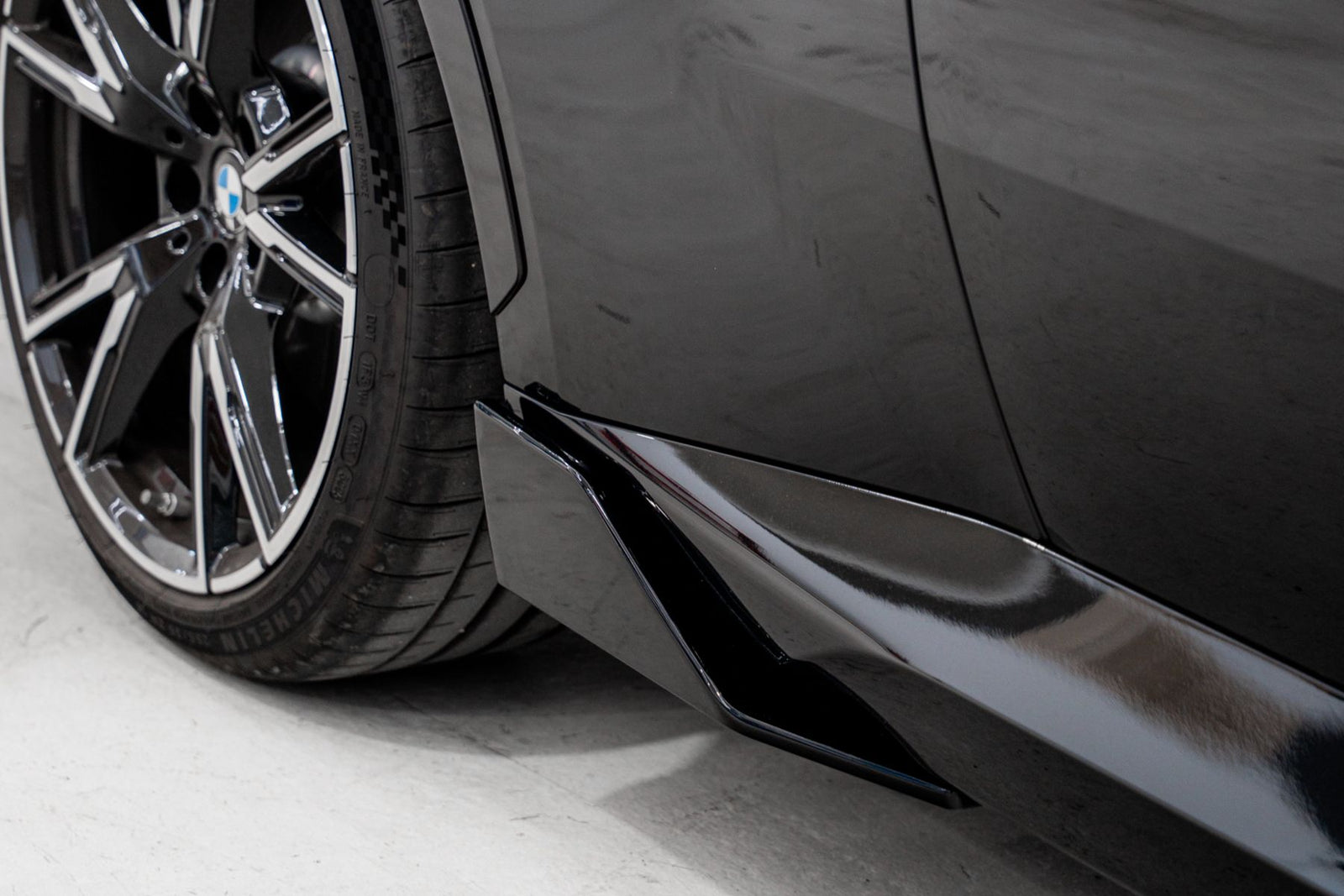 BMW G42 gloss black side blade winglet detail behind front wheel