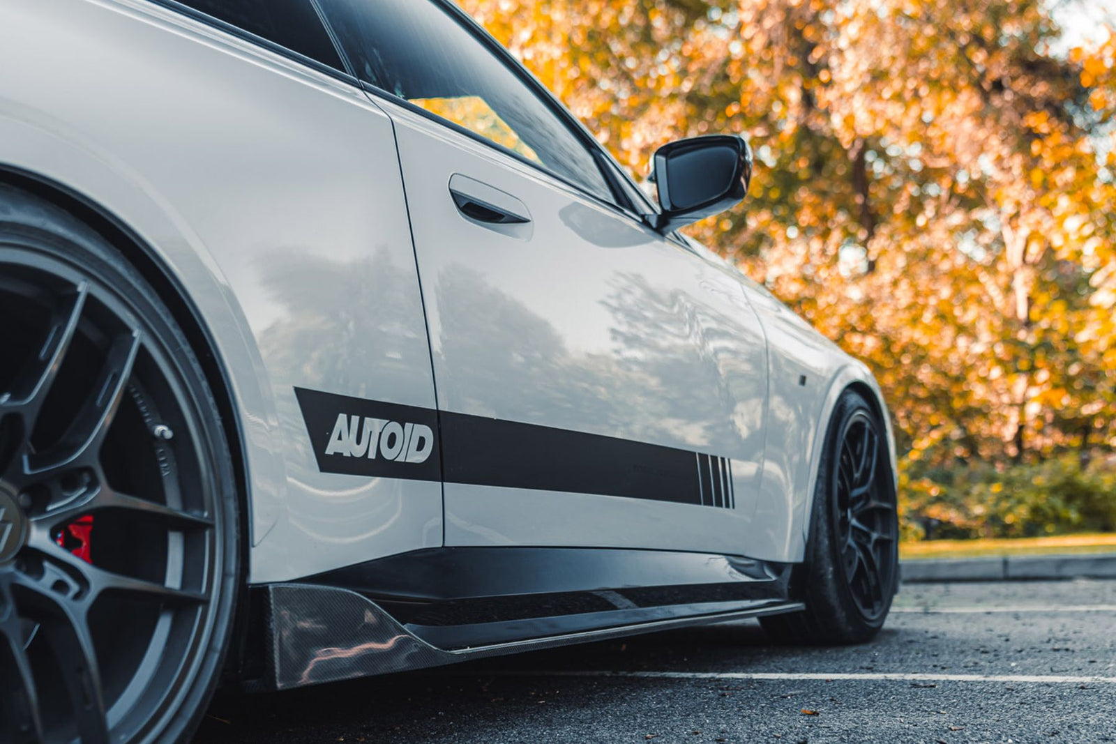 BMW G42 M240i white with carbon fibre full length side skirt low angle kerbside view